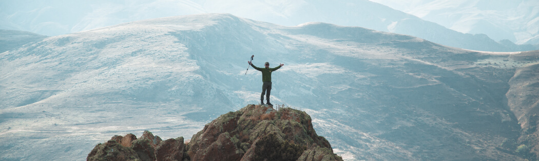 Happy man on top of the mountain